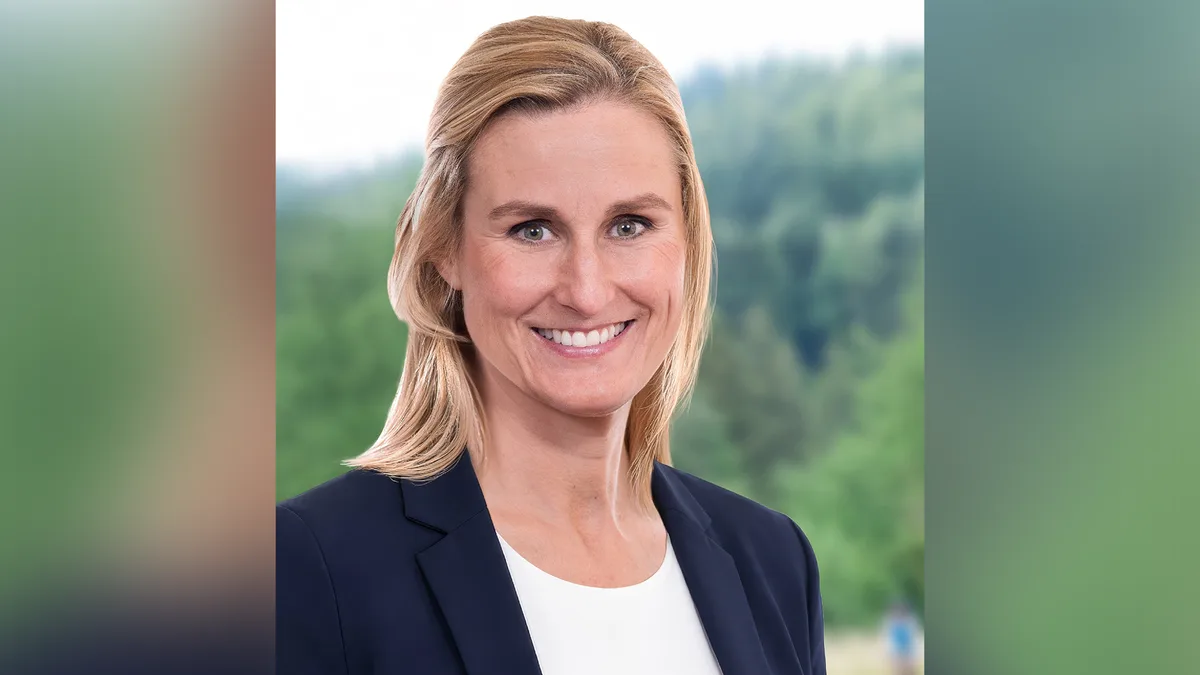 Porträt einer Frau mit weissem Shirt und blauem Sakko.